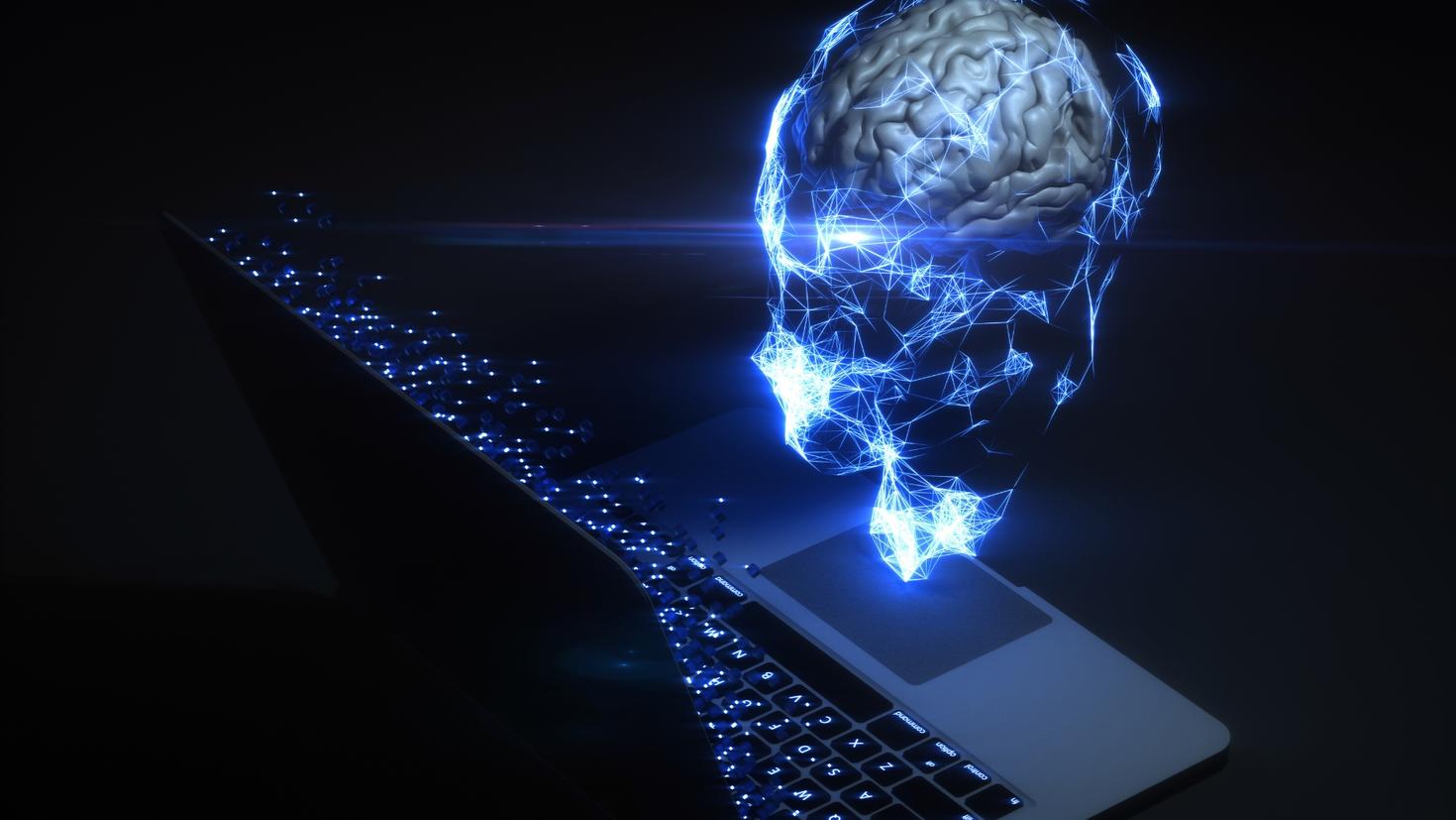 A computer rendering of a transparent head with a brain inside in front of a computer screen.