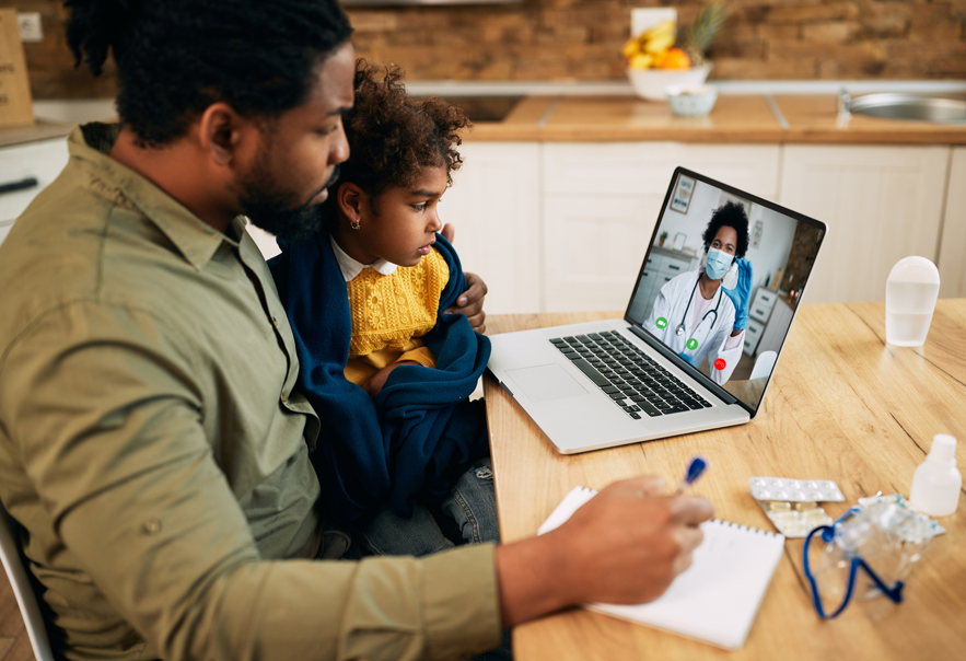 A dad with his child looking at a laptop screen