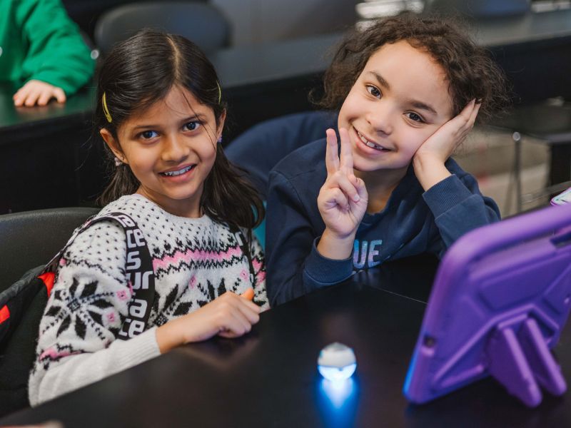 Deux enfants souriants dans une salle de classe