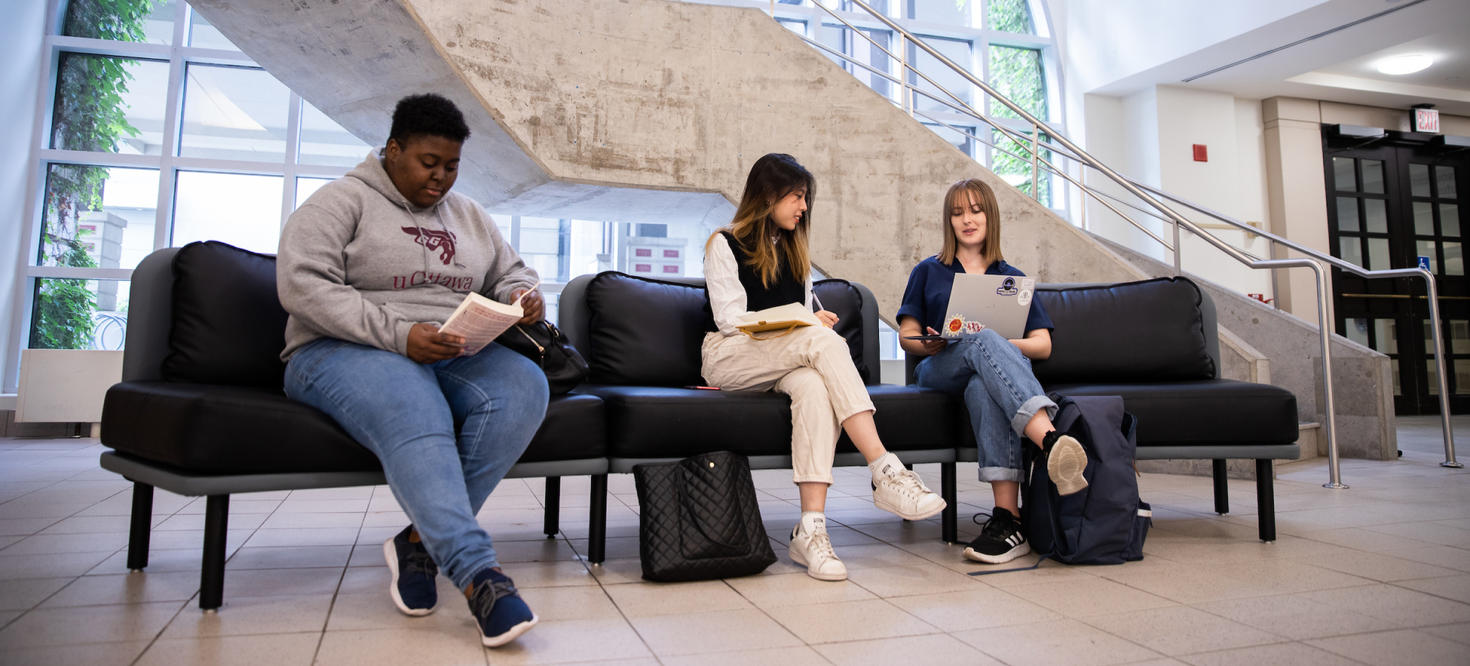 Students sitting on a bench inside