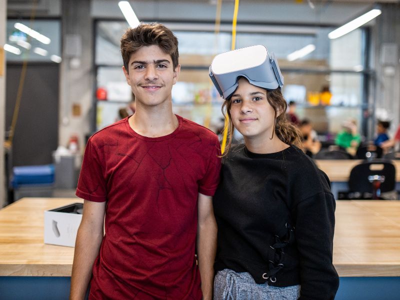 Two high school students in the Makerspace smiling