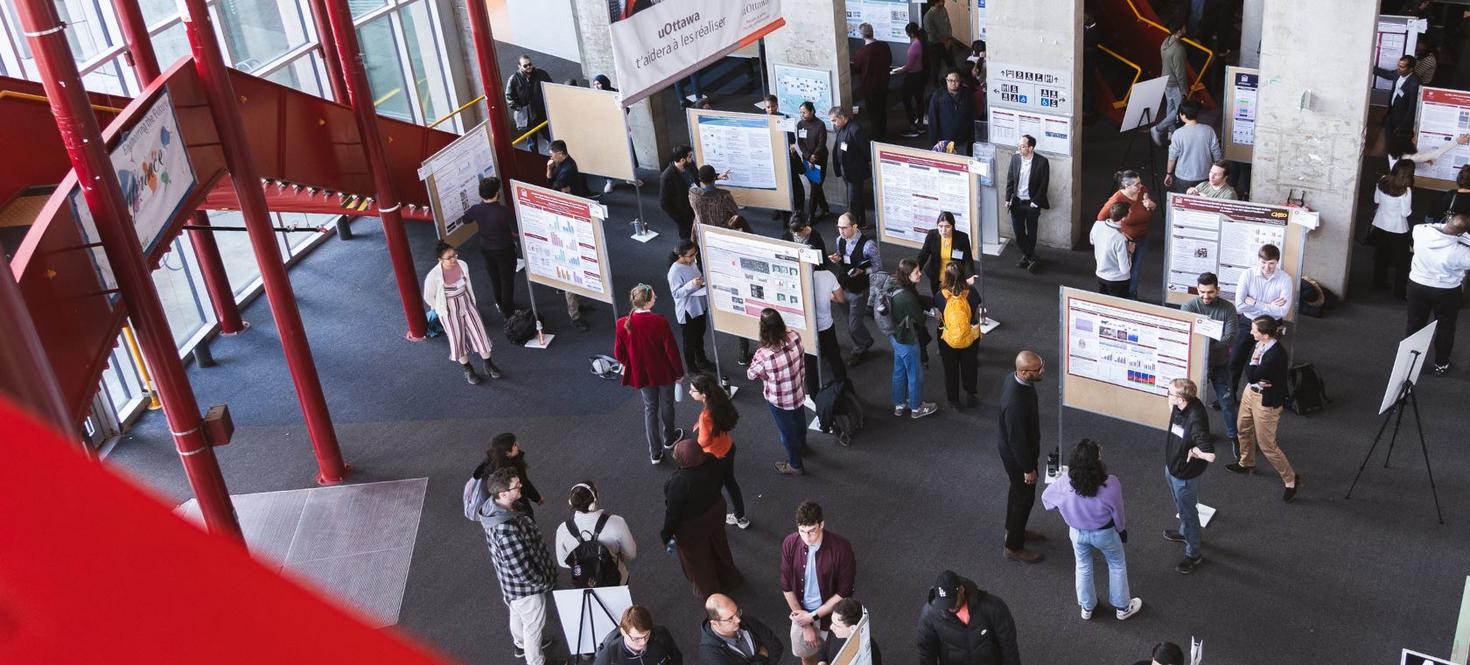 Aerial view of people walking around poster displays.