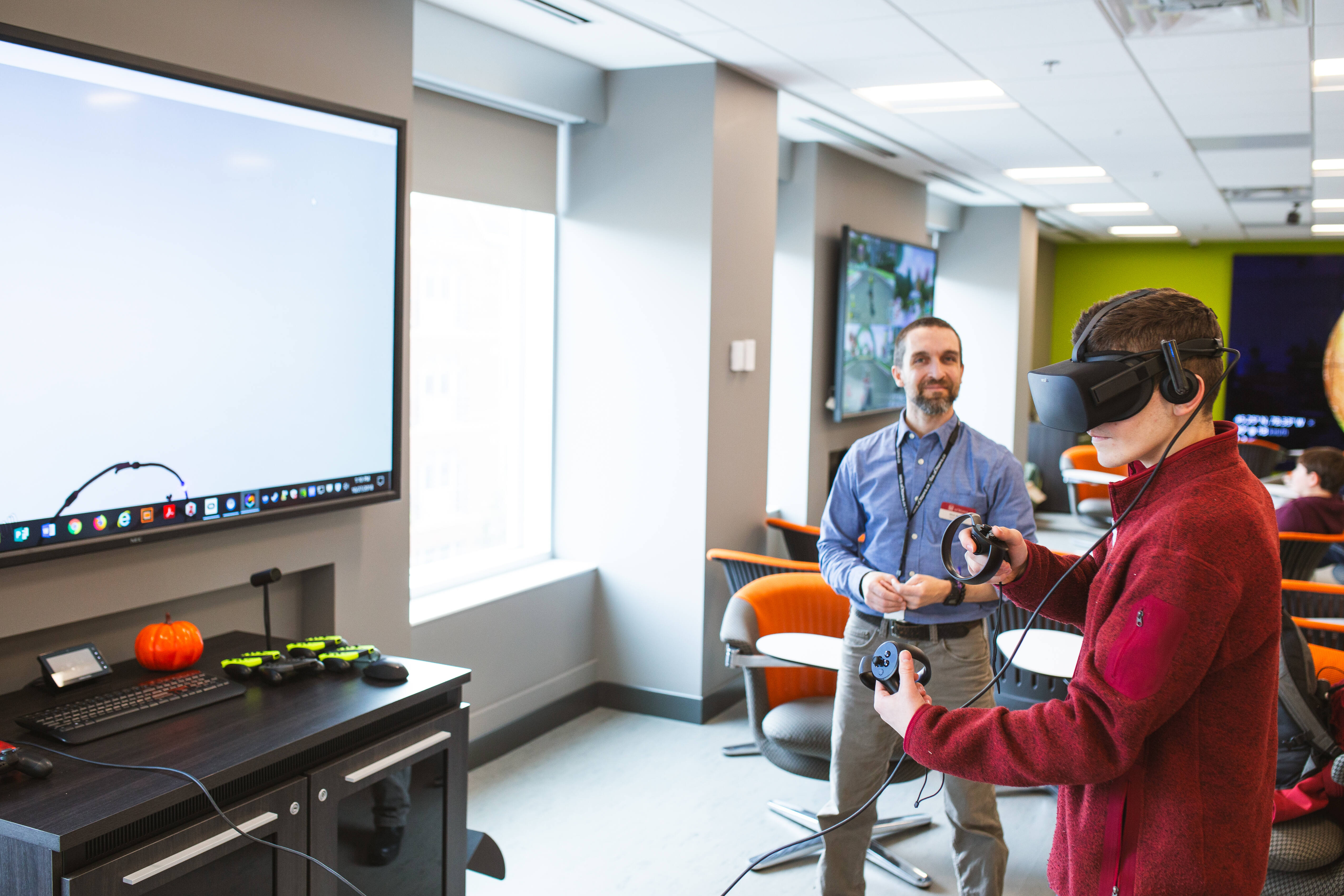 A student uses a VR headset with a member of staff