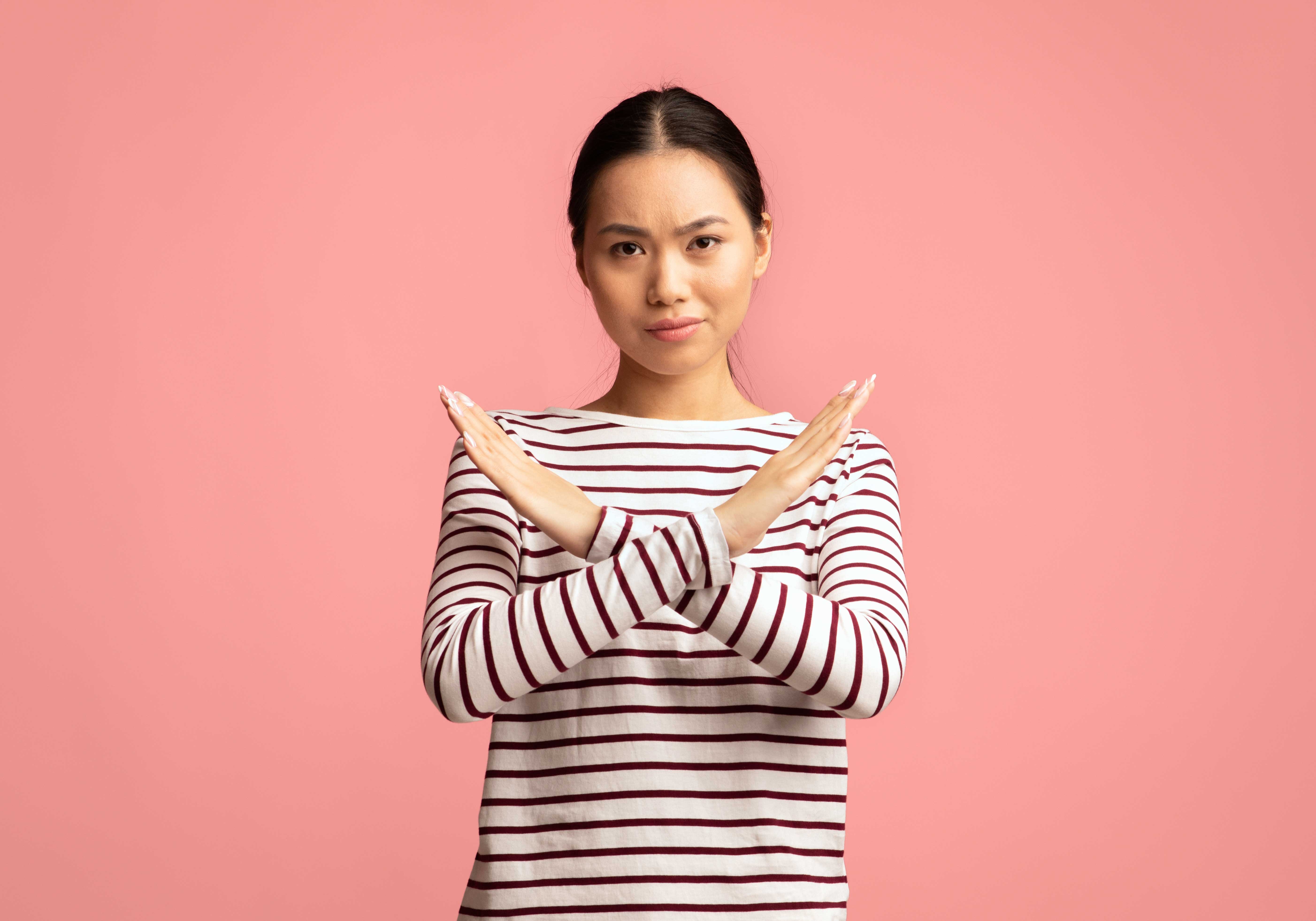 Femme avec les bras croisés devant le corps en forme de x