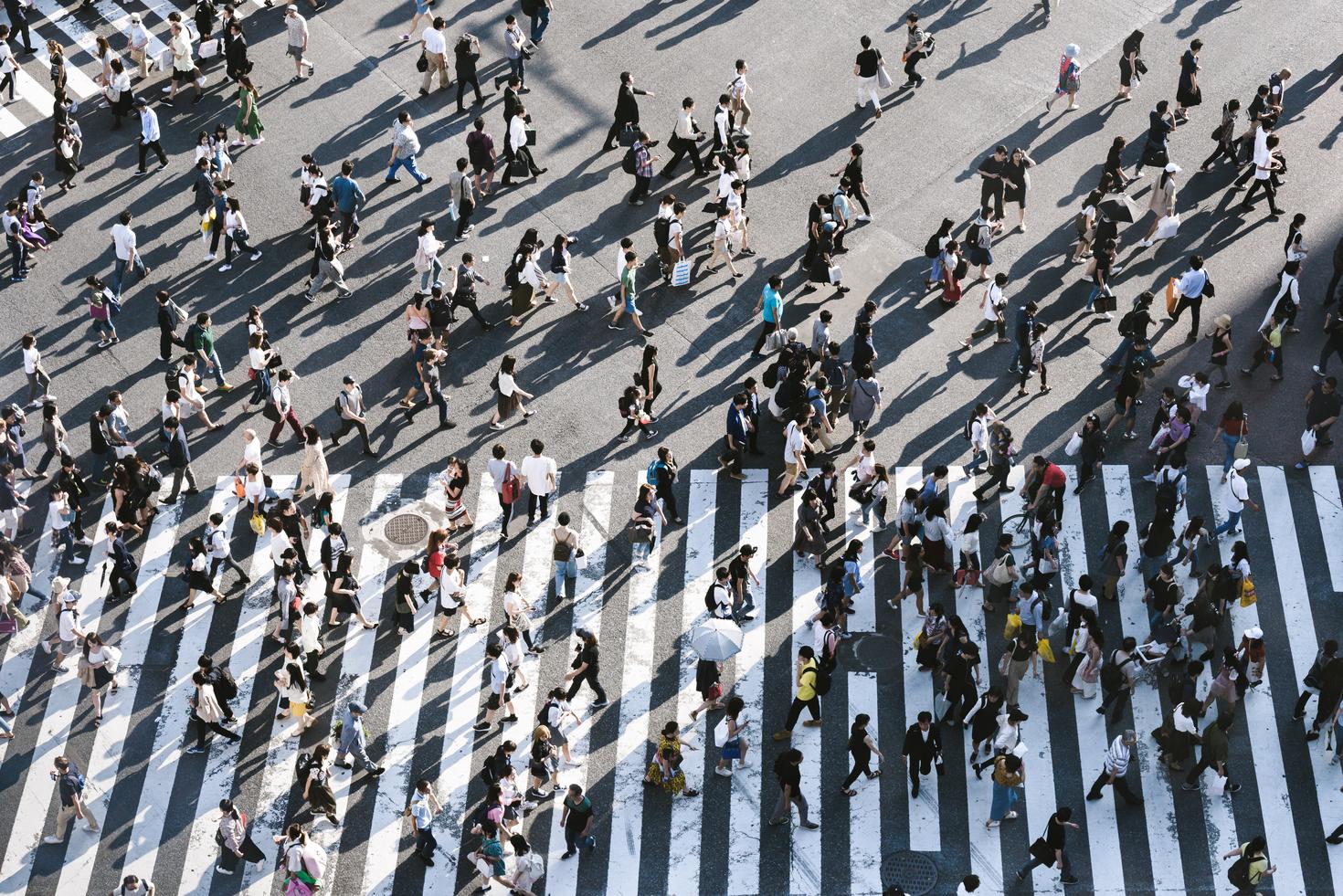 Crowd of people crossing street.