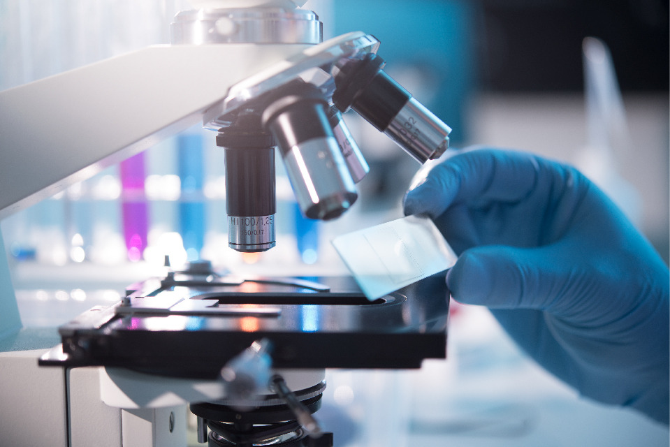 un microscope avec un main portant un gant