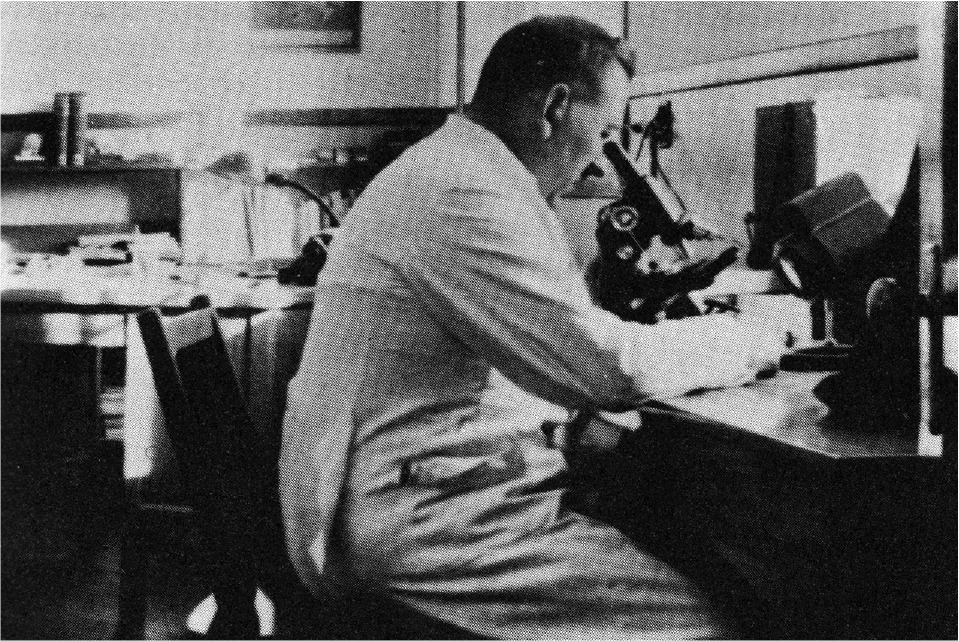 Leonard Belanger peers into a microscope