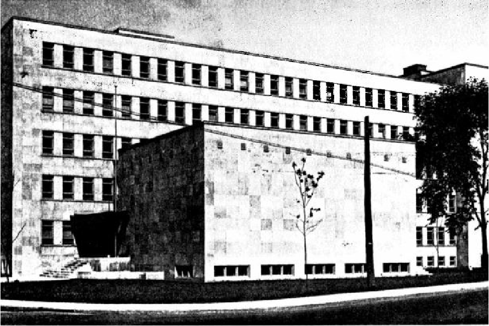 A square concrete building with rows of windows