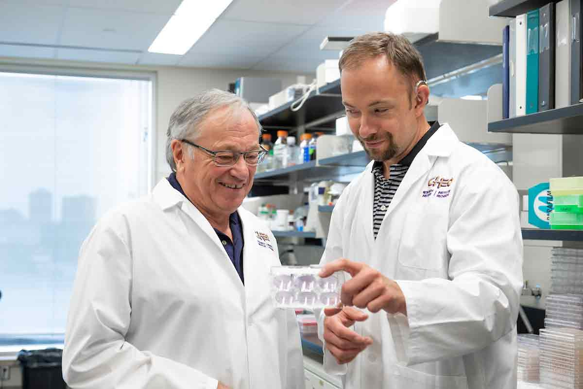 Photo of Dr. Robert Korneluk and Dr. Shawn Beug in the laboratory.