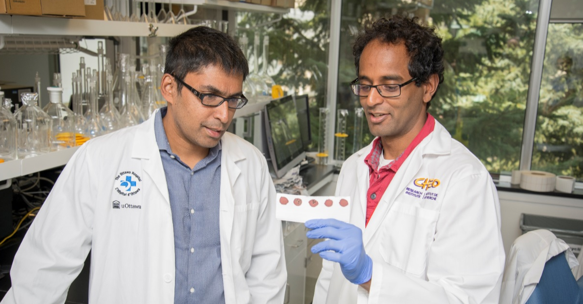 Les Docteurs Kumanan Wilson et Pranesh Chakraborty analysant des tests dans leur laboratoire.