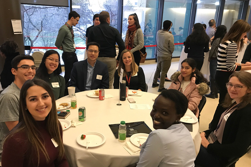A photo of students and faculty sitting at a table.