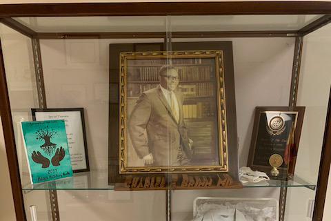 Une photo d’une vitrine où est exposée une photo encadrée du Dr Charles Brimm.
