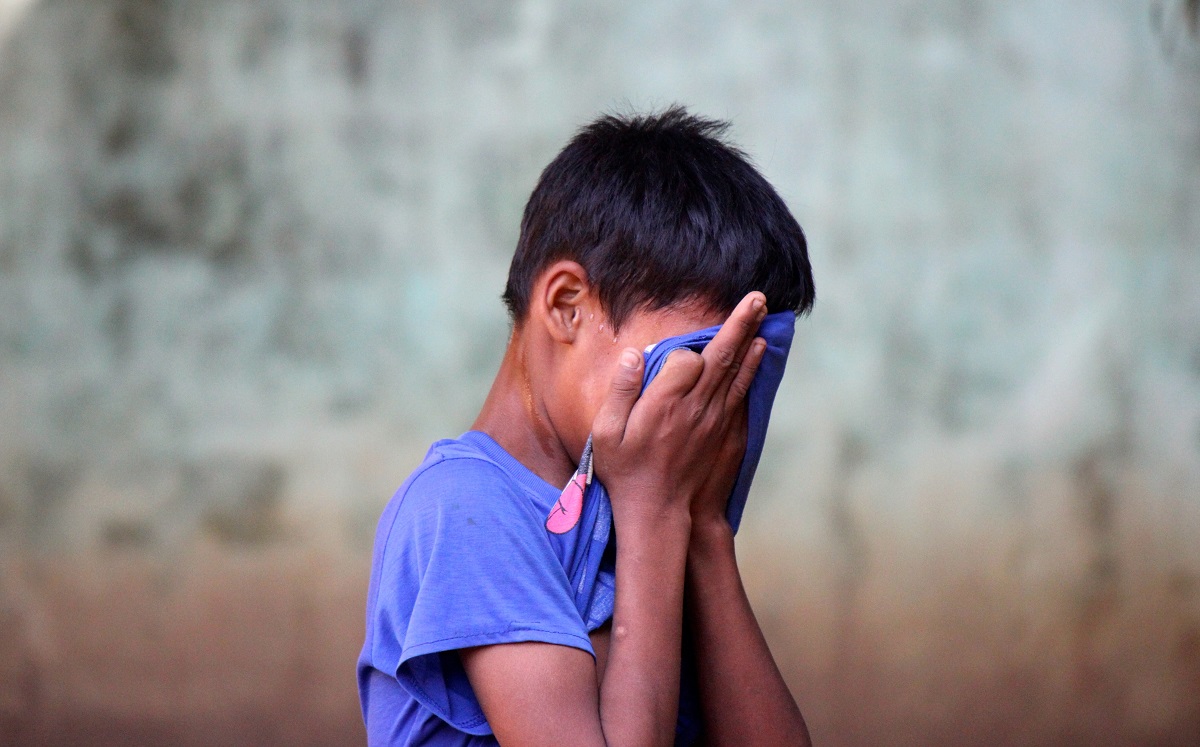 Jeune garçon Rohingya avec la tête dans les mains