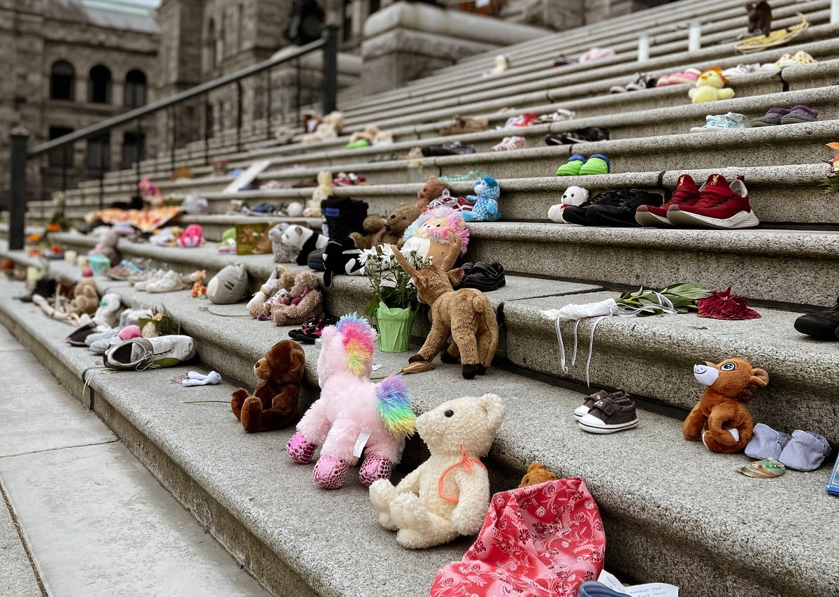 Children's shoes, dolls on steps to symbolize Truth and Reconciliation