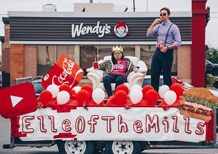 Elle Mills sitting on a float festooned with balloons in a Wendy’s parking lot.